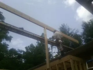 Carpenter setting a ridge beam over a new addition frame — Ice Dam Removal by Roofing Brothers in East Lynne