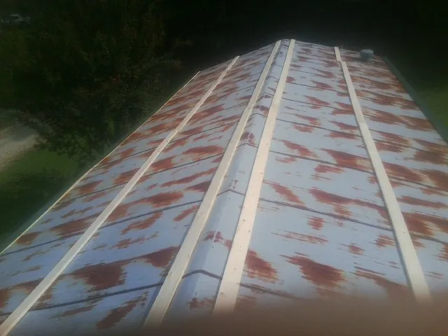 Rusted metal roof panels with new wood purlins before replacement — Storm Damage Roof Repair in East Lynne by Roofing Brothers