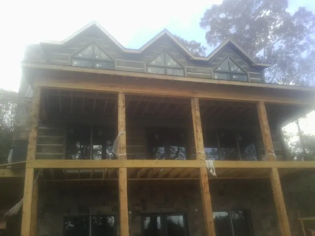 Dormers and porch framing on a large log home under construction — Roof Coating work by our crew in East Lynne