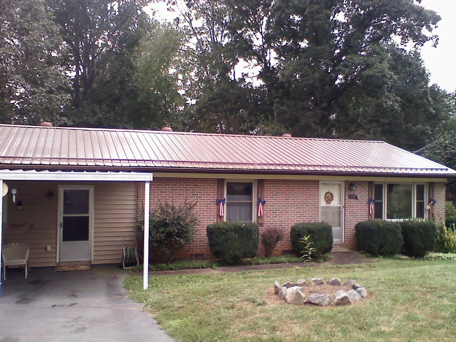 Bronze metal roof and carport on a brick ranch home — Roof Repair work by our crew in East Lynne