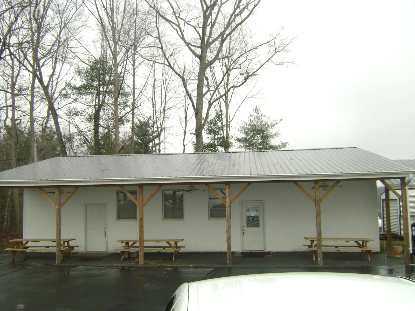 Gray metal roof over a block building with a timber post porch in East Lynne